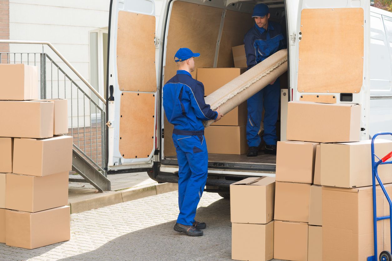 Two men loading boxes into a moving truck.